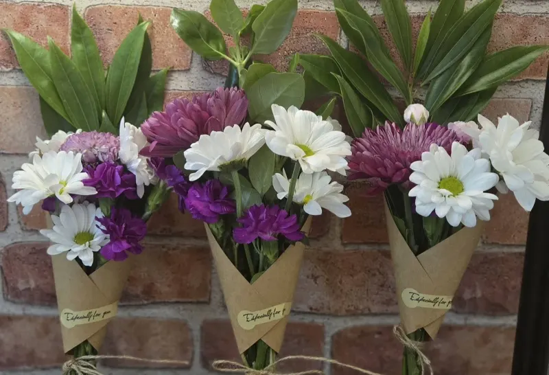 Wrapped bouquets in front of a brick background